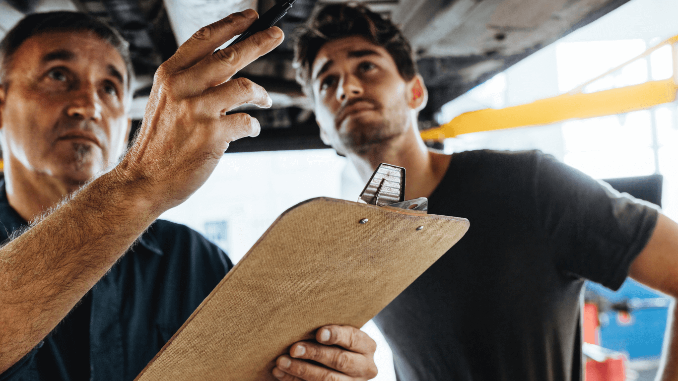 mechanic showing customer what auto repairs need done